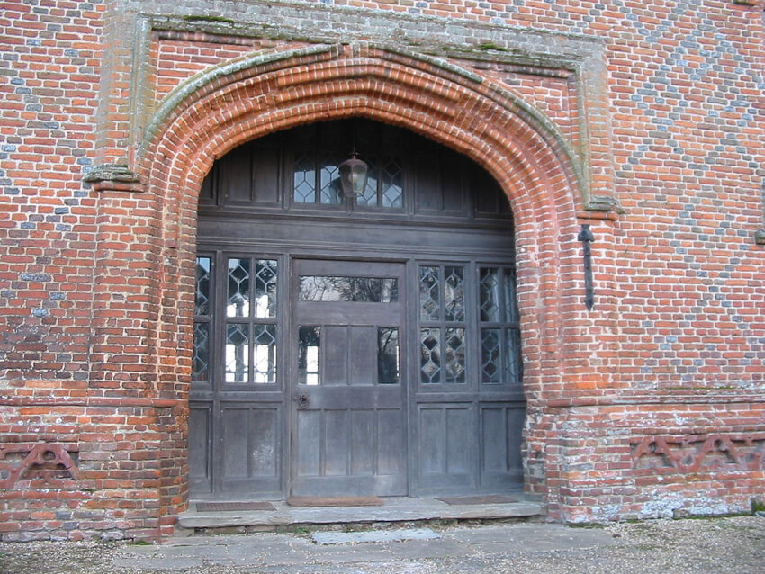 A brick wrought entrance of an ancient Tudor architecture building