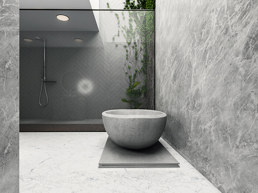 stone bathtub in a modern bathroom with skylight and stone flooring