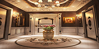 The entrance lobby of a classic apartment with stone flooring and a large golden flower pot