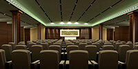 a large conference hall with cream color furniture and wooden walls