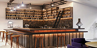 a wooden bar of a modern restaurant with decorative wooden wall and modern lighting fixtures 